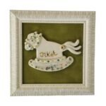 Įrėmintas keramikinis arkliukas yra rankų darbo pagamintas iš  balto molio ir nuglazūruotas. Įrėmintas plastikiniame rėmelyje.